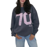 Person wearing a gray sweatshirt with pink '70' print